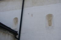 Die romanische Quadermauer am Langhaus mit zwei vermauerten Trichterrundbogenfenstern aus dem 12. Jahrhundert